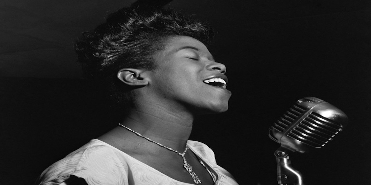 Black woman jazz singer, singing into microphone