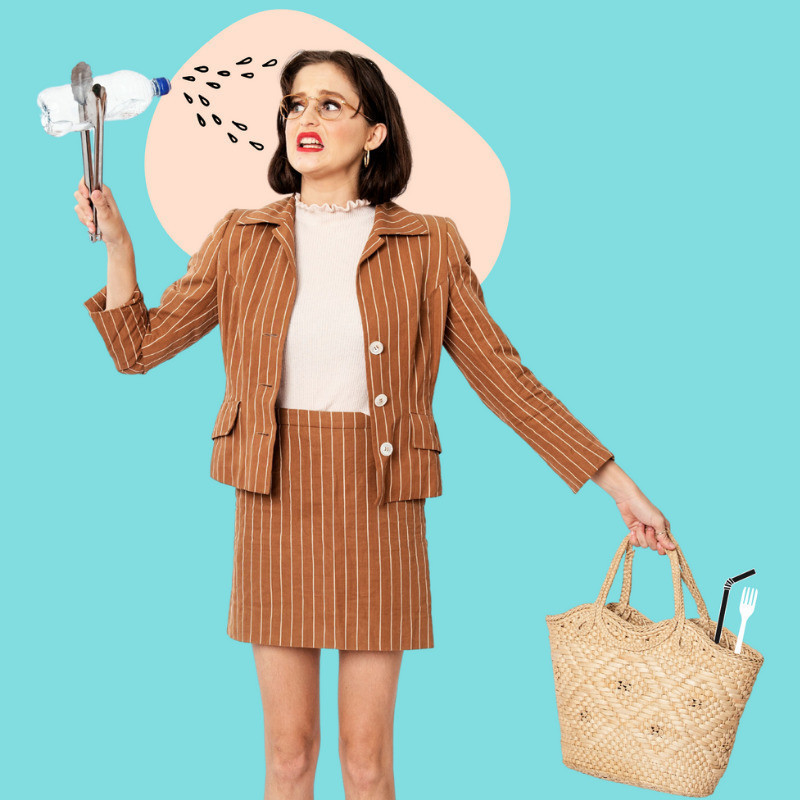 Girl in brown and white striped skirt suit.
She is holding a plastic bottle with a pair of kitchen tongs to her face.
She is pulling a funny face it is scrunched up in distress from the plastic.
