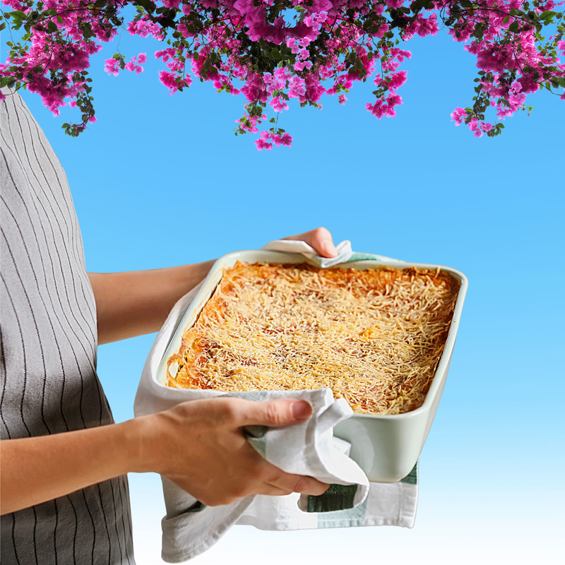 Unperturbed - Faceless woman holding a tray of lasagne. Bougainvillea plant dangling from a blue sky.