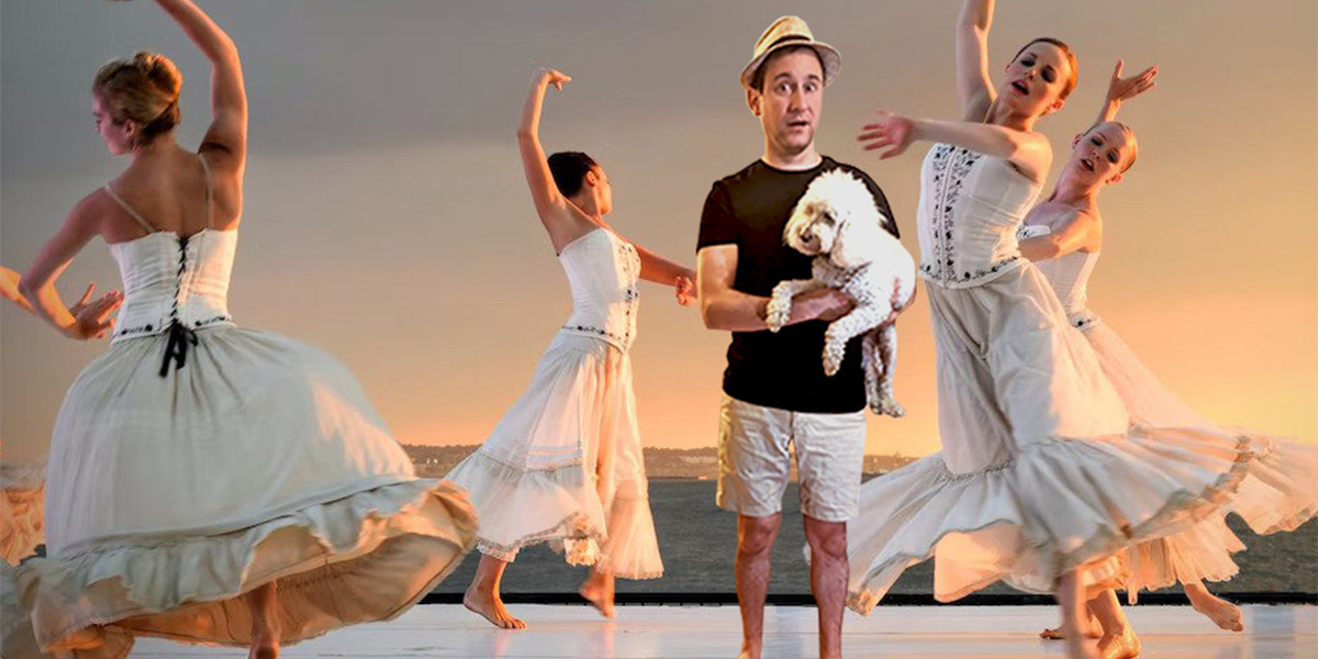 A man clutching a dog while standing on a stage. There is a ballet being performed around him.
