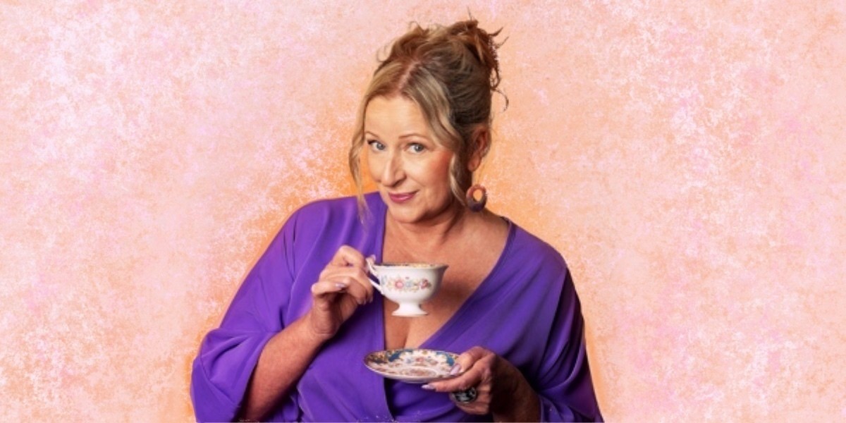 Lady in lilac dress holds teacup and saucer with pinky raised and a cheeky smile