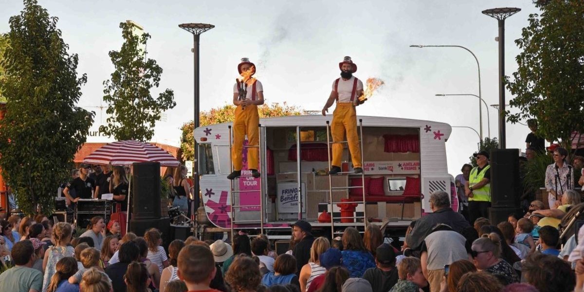 two circus style performers on stilts in Sixth Street