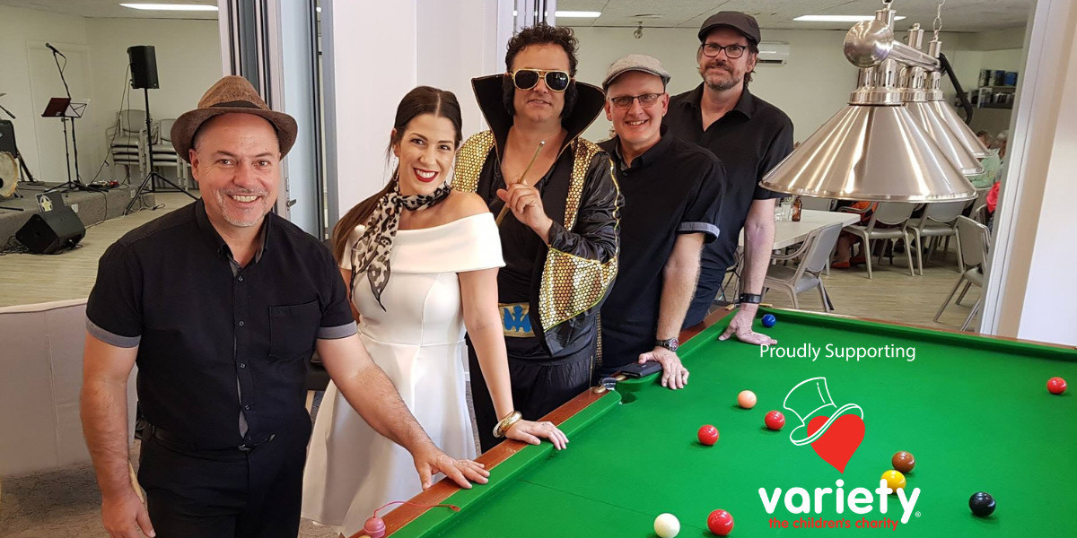 Frank is lined up next to Dani who is wearing a lovely white dress. Tony is dressed as Elvis Presley and is standing next to Nige and Ken near the pool table.