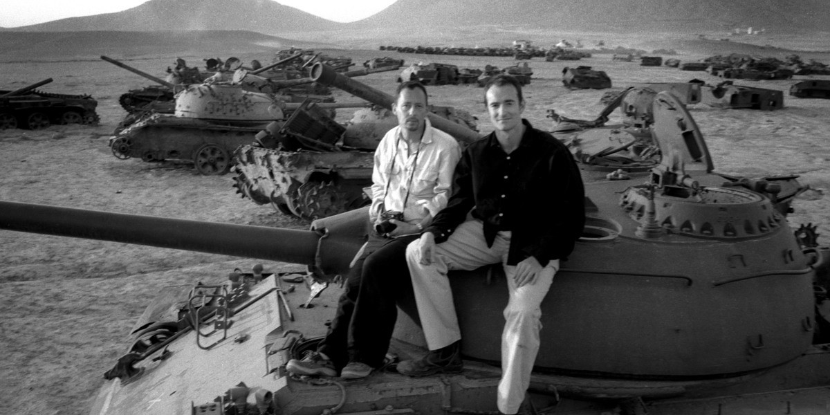 A black and white photo of Henry Naylor and Sam Maynard sit on a tank in the war zone in Afghanistan