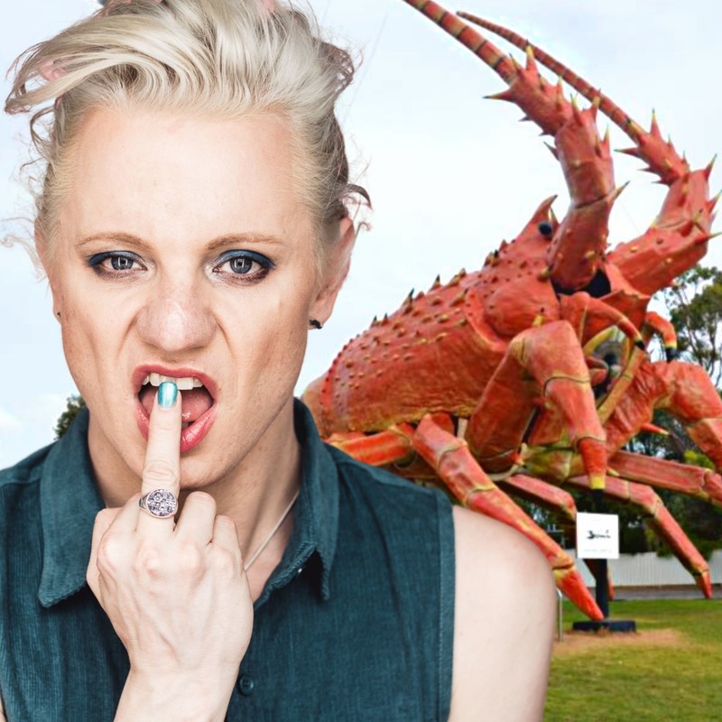 CANCELLED - Glace's Big Things - Trans Queen Glace Chase derisively flips the middle finger to the camera standing in front of Larry, the menacing orange big Lobster statue.