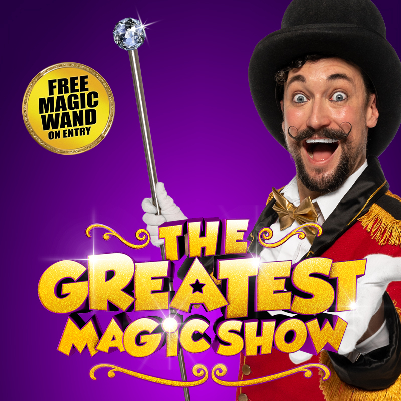 Production image of Ringmaster Character holding out hand towards camera against Purple Background. Golden "The Greatest Magic Show" logo centre. "Free Magic Wand on entry" words to the left.
