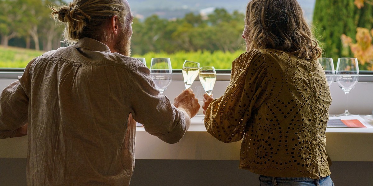 Gathering Experience - a couple enjoying a glass of sparkling while enjoying views over the vineyard