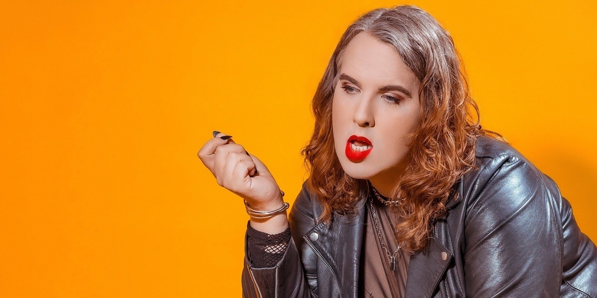 Anna Piper Scott, wearing black leather jacket in front of yellow background
