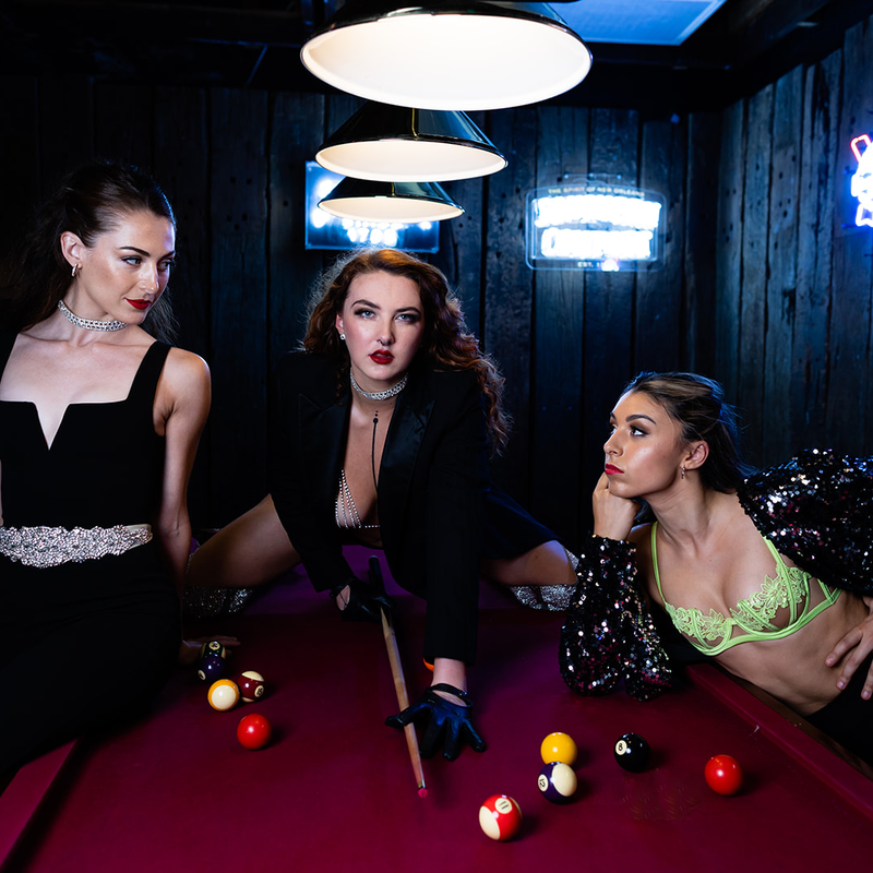 Image of Fafi D'Alour playing pool with her two Delinquents on either side
