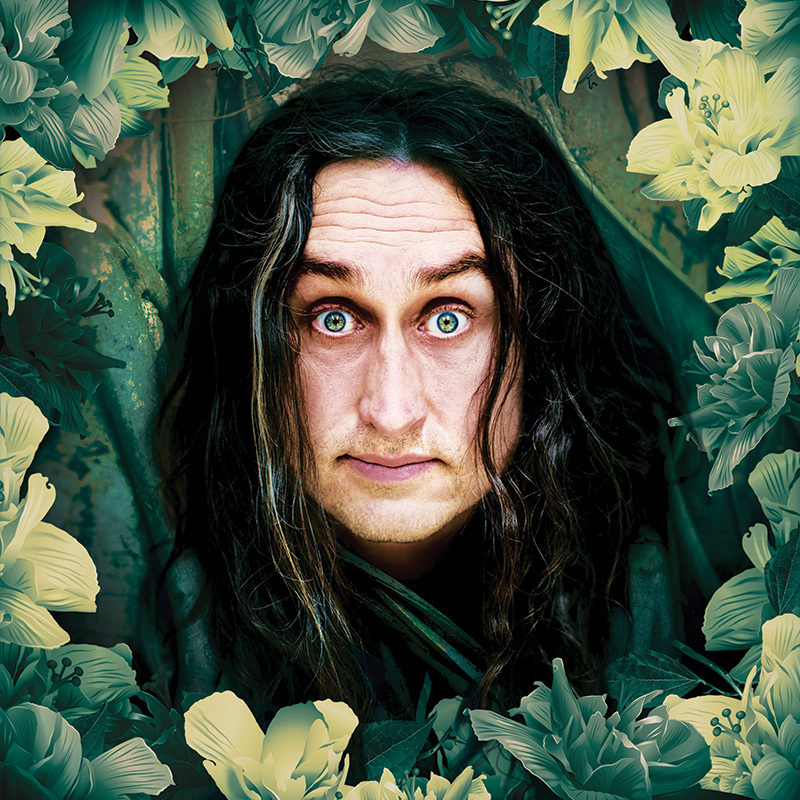 Image of Ross Noble wearing a black long sleeve button up shirt with his arms crossed, looking at the camera