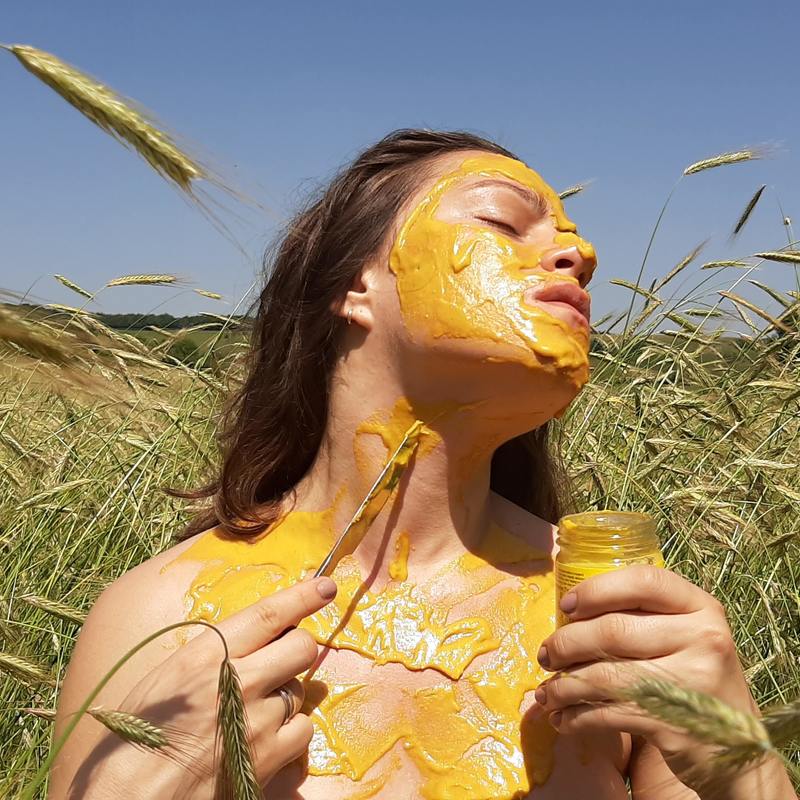 image of a girl smearing mustard all over her skin
