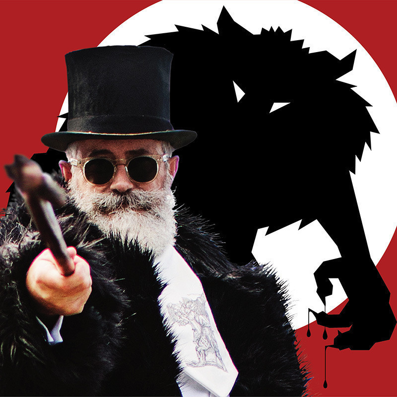 The Werewolves games master in top hat and fur coat points his walking cane at the screen and standing behind him leering over his shoulder is a huge werewolf.