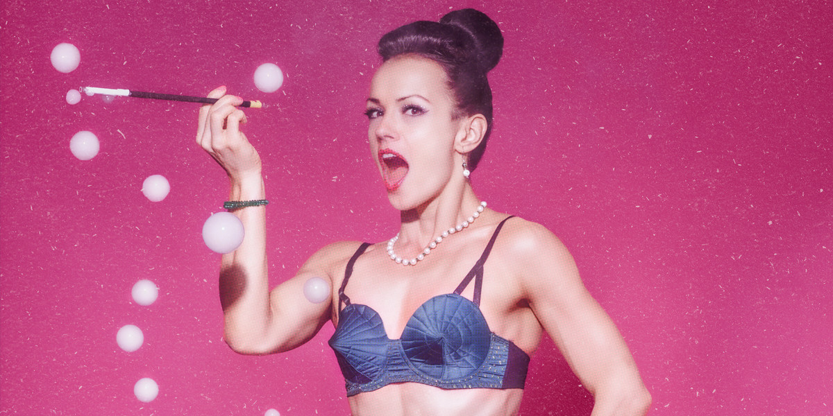 woman holding cigarette holder making smoke bubbles wearing only a 1950's bra