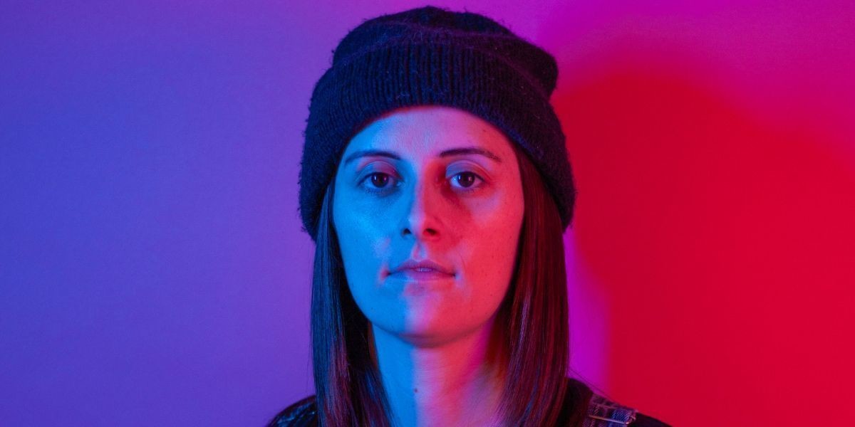 Annie wearing a beanie on a cool red and blue background.