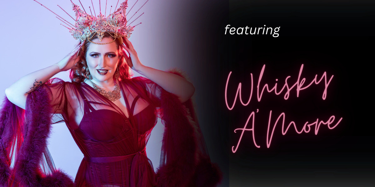 Whisky is wearing a gold spiked crown and a flowing burgundy coloured robe. She is looking at the camera and holding the sides of the crown with both hands. One half of the image there is the text 'featuring Whisky A'More' on a black background.