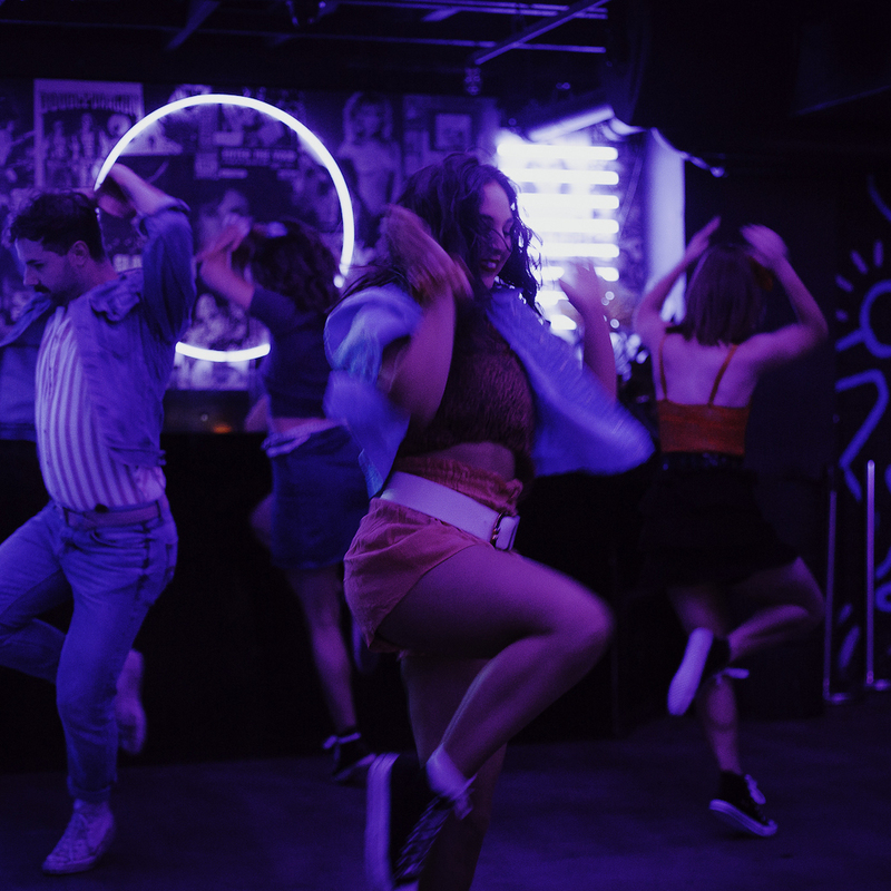 80s nightclub dance floor with 5 dancers doing the same move