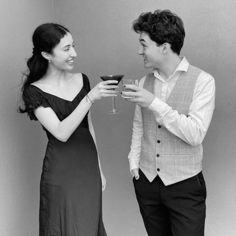 A woman and man toasting cocktails.