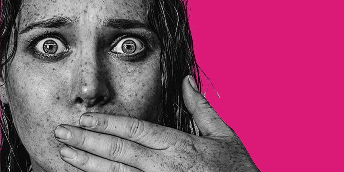 Joana Joy: Standing Still - Black and white overexposed close up headshot of Joana Joy, New Zealand European woman- on top of a magenta background. Joana's facial expression features her eyes wide and holding hand over mouth. Joana has lots of freckles and wet hair.