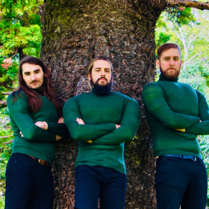 image of three people standing in front of a tree.