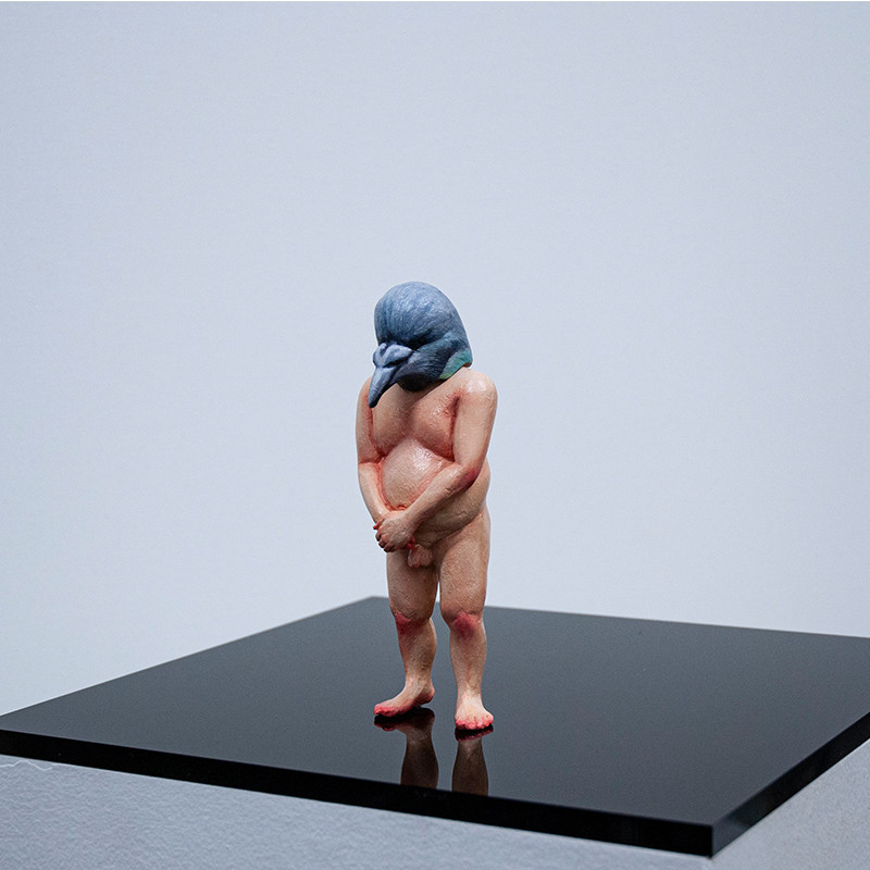 An image of a small figurine of a nude person with a bird head.