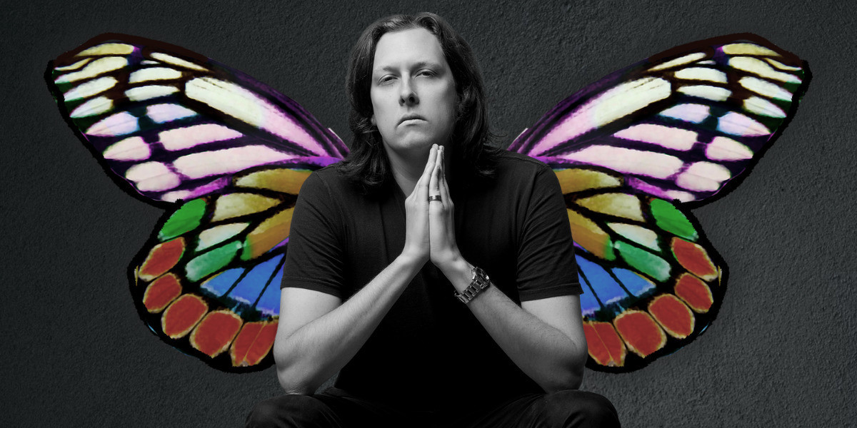 Jon with butterfly wings appearing from behind them. They are in front of a dark grey background.