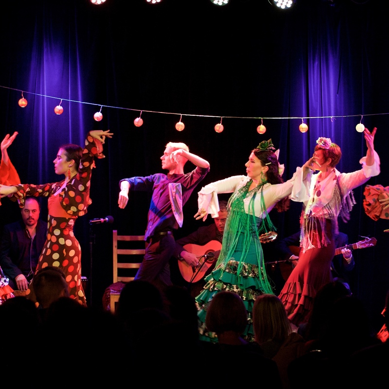 Group of flamenco dancers in brightly coloured costumes
