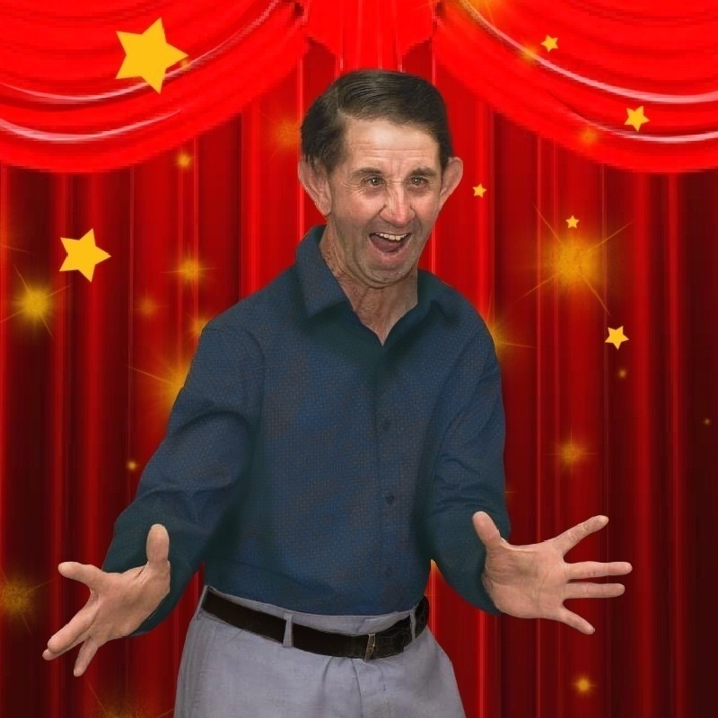 Kym's Overall Extravaganza Showcase - Volume 2 - Kym standing in front of red theatre curtains with Jazz Hands