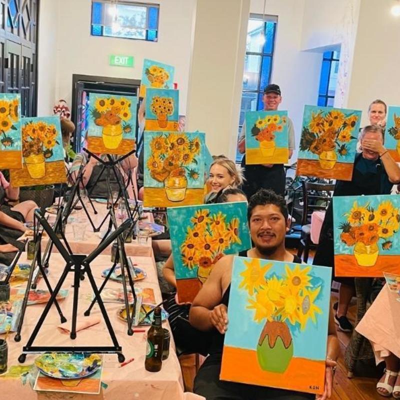 patrons holding up the painting created during our paint and sip session