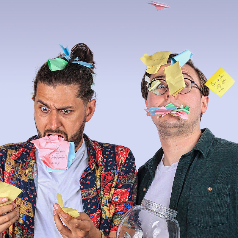 Comedians Shad Wicka and Peter James with post-it notes in their mouths.