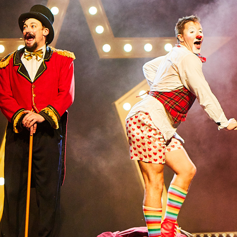 Live shot from the performance, Ringmaster character on the left, Clown character on the right posing in red love heart boxer shorts.