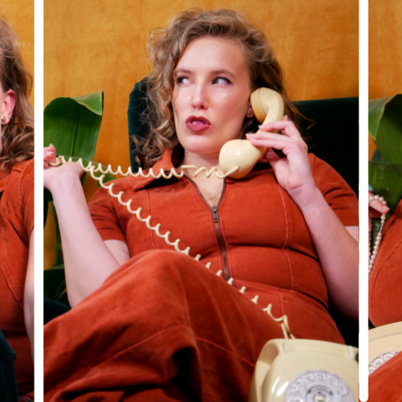 A triptych of 3 images side by side, split up by white lines. In all 3 photos Mim is wearing an orange jumpsuit, holding a retro phone, and sitting on a dark green armchair in front of a mustard background and beside a leafy indoor plant. In the first photos from the left she is holding the receiver away from her ear and looking up excitedly, a wide smile on her face. In the middle photo she is sitting cross-legged on the armchair, sucking her teeth and looking off to the left of frame with an expression that looks malicious. She is holding the phone receiver in her left hand and pulling the curly cord of the phone across her body with her right hand.  In the far right photo she is holding the receiver to her ear and laughing with her eyes closed.
