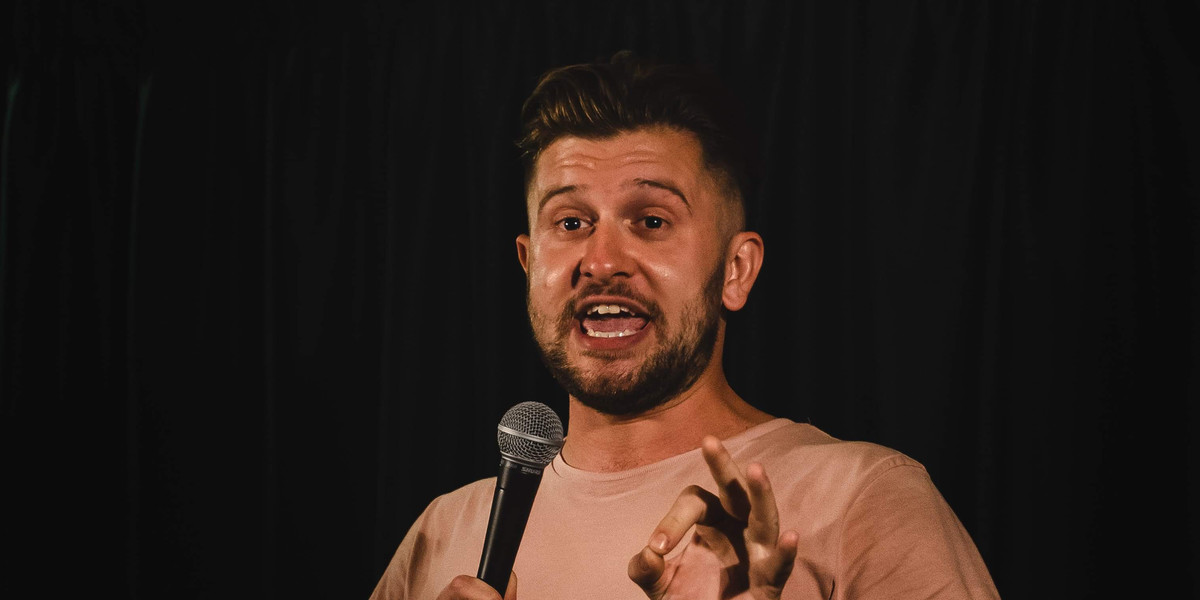 Grant Mushet on stage performing comedy
