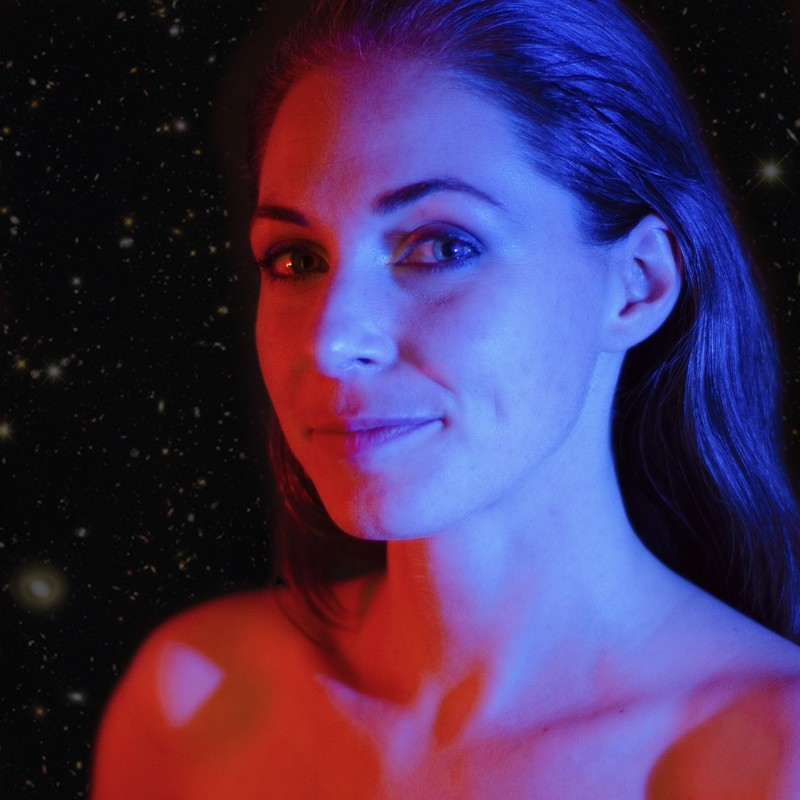 Presenter, Rachel Rayner Science Explainer in red and blue lighting with a starry background