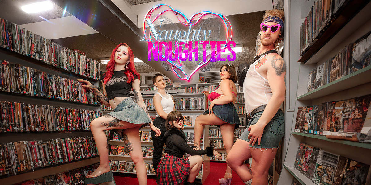 Five people dressed in 2000's style outfits stand posed in a video rental store. They are surrounded by shelves full of DVDs. Two of the women are wearing denim mini skirts and have one leg propped up on the shelves. One woman is crouching on the floor with sunglasses, a fluffy black jumper and a red plaid skirt. There are 2 people with white tank tops leaning against the walls on either side. In the top centre of the image there is text that reads 'Naughty Noughties" which is written in a sparkly font. The text is on top of a silver metallic heart and a silver butterfly.
