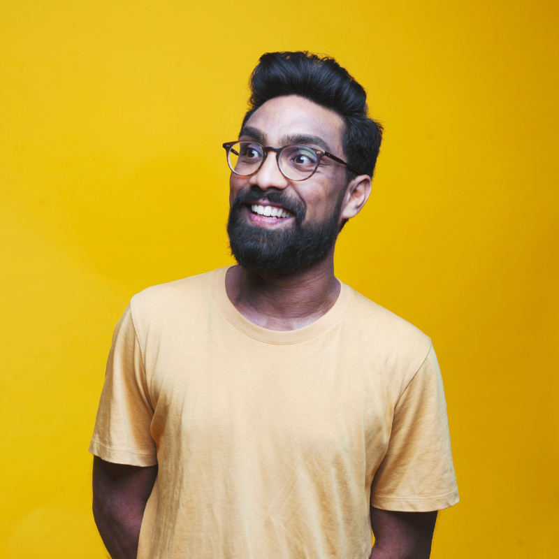 Suren Jayemanne has a big grin while wearing yellow shirt with yellow background