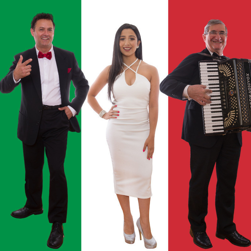 Tony is dressed in his formal suit on the left. Sophia is in the middle dressed in a beautiful white dress with sparkly shoes. Lino is standing on the right with his piano accordion in hand.