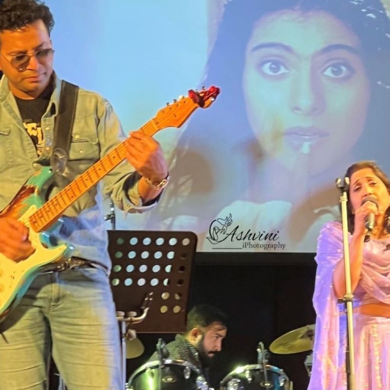 male guitarist and a female singer with microphone in hand on stage