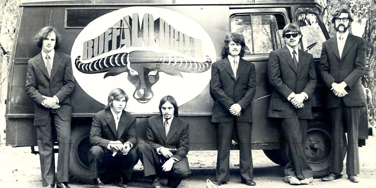 Buffalo Drive owned an old Commer van, painted either side with their other logo - that of a buffalo head - which they used to haul their equipment from venue to venue, both locally in Adelaide, and further afield interstate.
Original members standing in front of the band are, from left to right: Rod Boucher (lead vocals, guitar, banjo), Vello Nou (keyboards & Hammond organ), Hayden Hill (guitar & vocals), Rodney "Bodzac" Dunn (drums, percussion & vocals), Valdis Adamsons (lead guitar & vocals), Graham "Grimy" Bettany (bass & vocals).