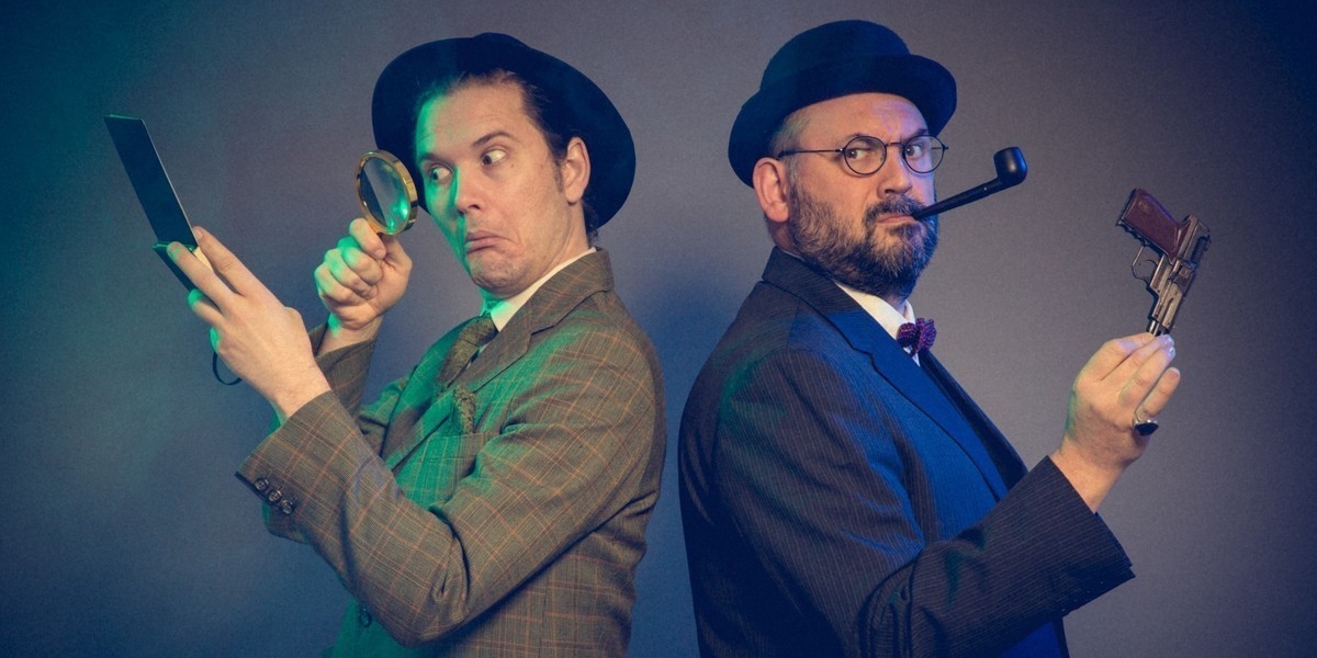 Two men dressed in mid-20th century suits stand back-toback. The man on the left wears a fedora and reads over a notepad with the air of a magnifying glass, while the one on the right has a bowler hat, smokes a pipe and holds a gun as he looks to the camera knowingly.
