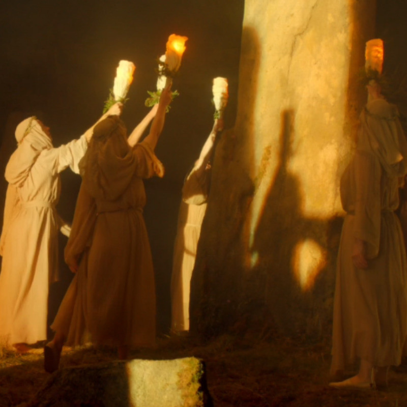 Dance of the Druids - A group of dancers hold up lanterns to the rising of the sun.