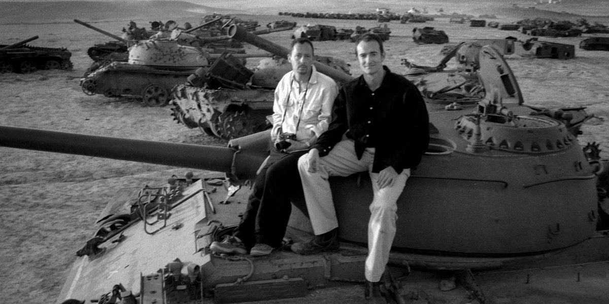 Playwright Henry Naylor and Photographer Sam Maynard sit on a military tank in Kabul
