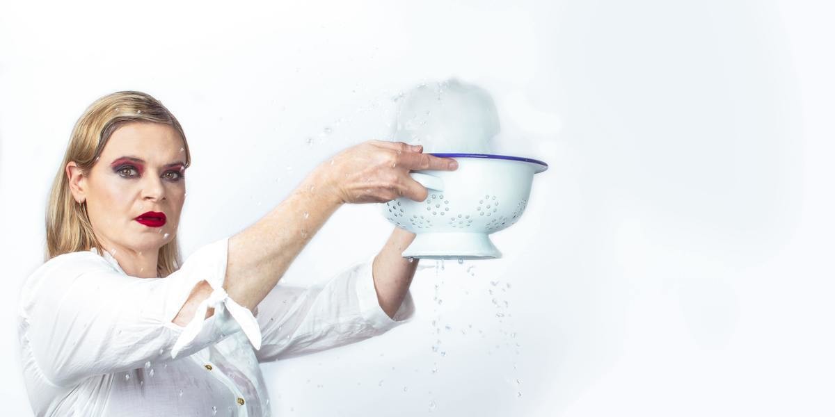 Woman in white shirt holds a collander full of melting ice