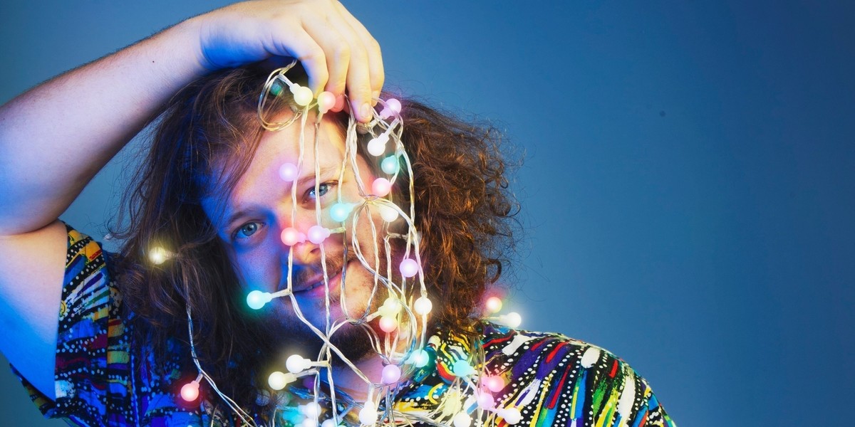 Blake holds fairy lights over his face.