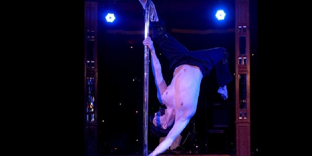 A male pole dancer performs