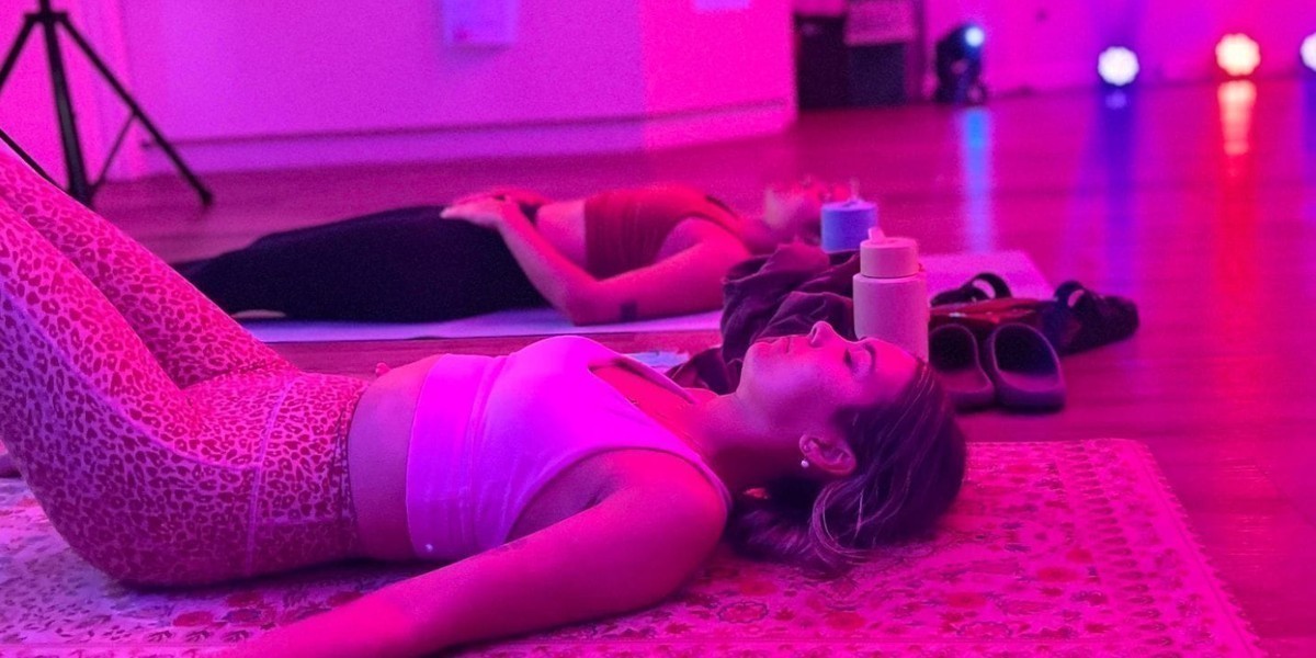 People lying on yoga mats, with rave lighting