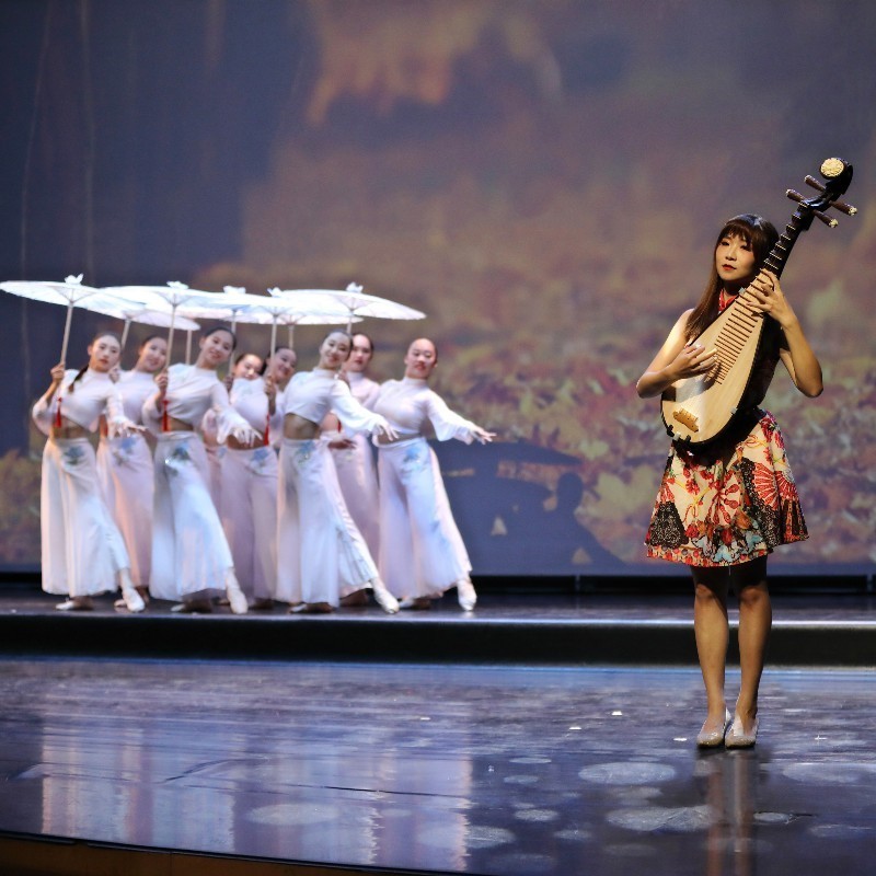 A Touch of Formosa Heart - performers hold umbrellas and smile in the background, while a performer holds a musical instrument in the foreground