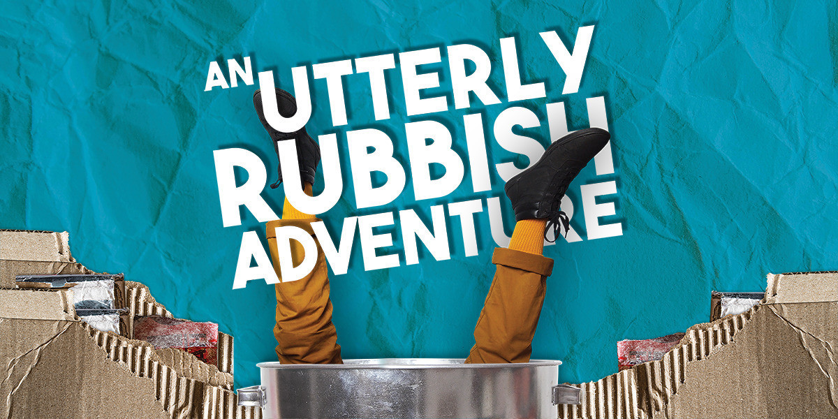 An Utterly Rubbish Adventure - Two legs in yellow pants poke out of a metal bin nestled in cardboard rubbish. The background is blue, with a texture of crumpled paper. In between the legs, 'AN UTTERLY RUBBISH ADVENTURE' is written in bold white type.
