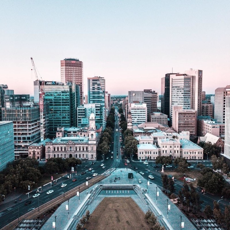 Home Thoughts - A photograph of the Adelaide CBD looking North from above Victoria Square. We look straight down King William Street towards the horizon