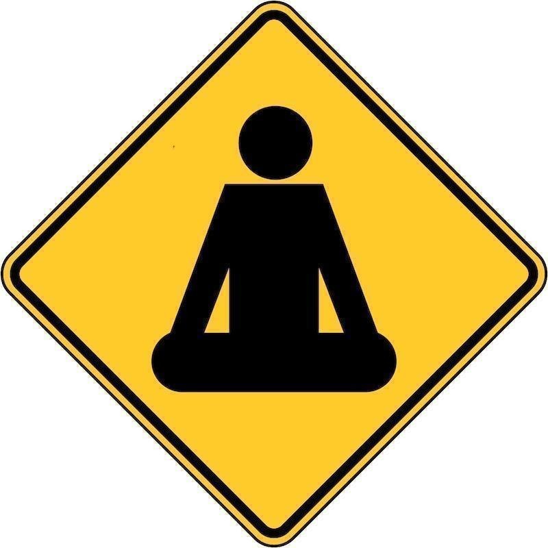 Try Buddhist Meditation - A diamond shaped yellow road sign with an image of a person meditating.