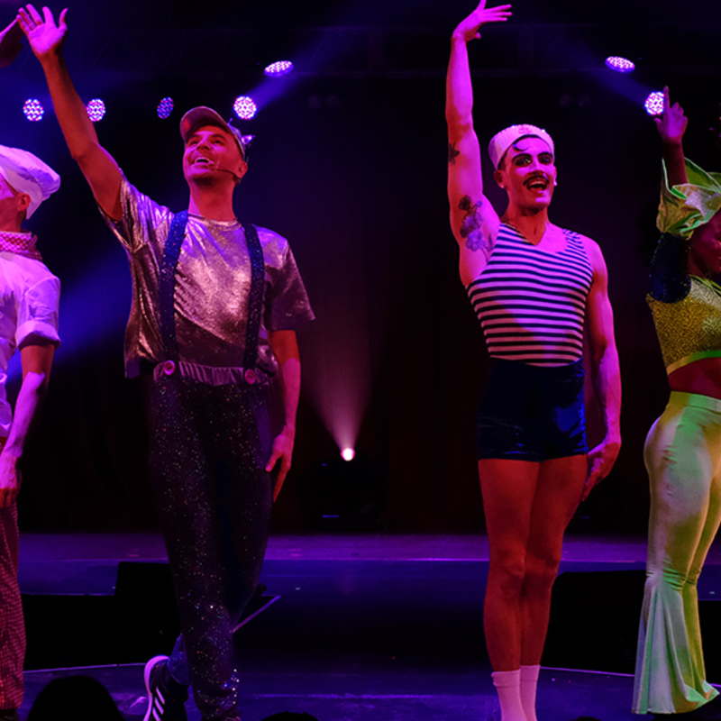 Five performers take a bow on stage in their costumes from the show.